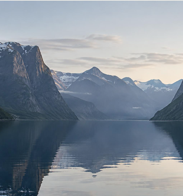 Still Norwegian fjord surrounded by layered mountains